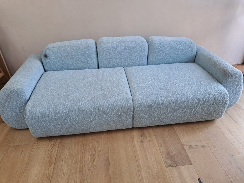 Lille blå sofa før rens med pletter og slid